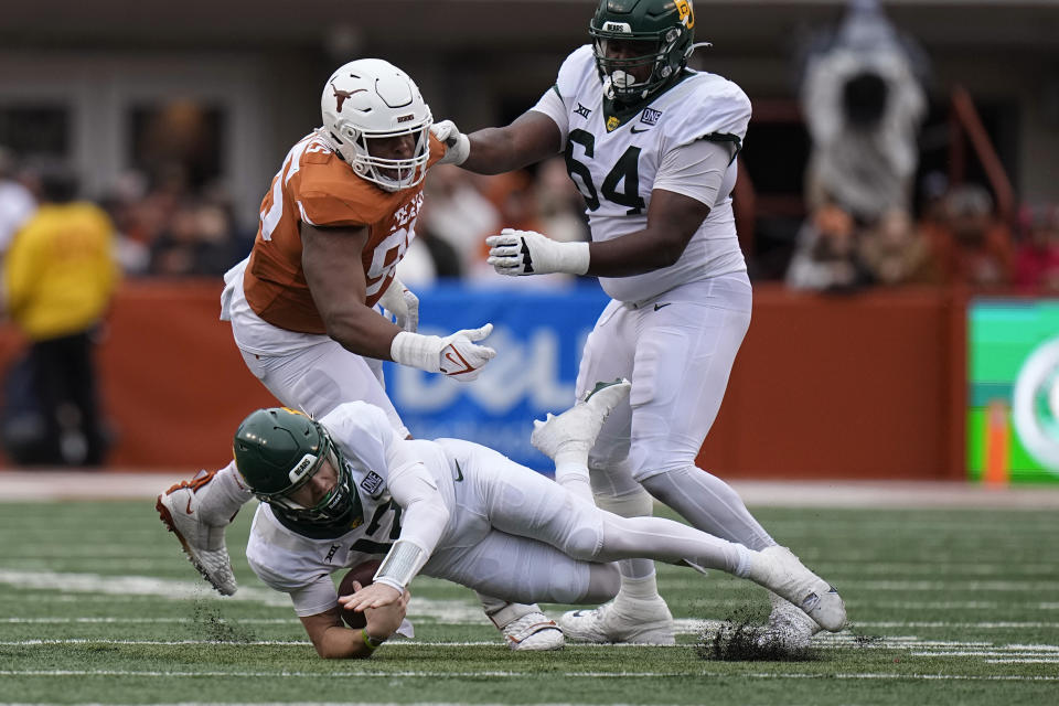 Baylor quarterback Blake Shapen (12) is tripped up by Texas defensive lineman Alfred Collins (95) during the first half of an NCAA college football game in Austin, Texas, Friday, Nov. 25, 2022. (AP Photo/Eric Gay)