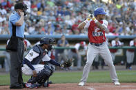 Home plate umpire Brian deBrauwere, left, taps on his earpiece as Liberty Division's Tyler Ladendorf, right, of the High Point Rockers, waits for a pitch from Freedom Division's Mitch Atkins, of the York Revolution, during the first inning of the Atlantic League All-Star minor league baseball game, Wednesday, July 10, 2019, in York, Pa. Also seen is catcher James Skelton, center, of the York Revolution. deBrauwere wore the earpiece connected to an iPhone in his ball bag which relayed ball and strike calls upon receiving it from a TrackMan computer system that uses Doppler radar. The independent Atlantic League became the first American professional baseball league to let the computer call balls and strikes during the all star game. (AP Photo/Julio Cortez)