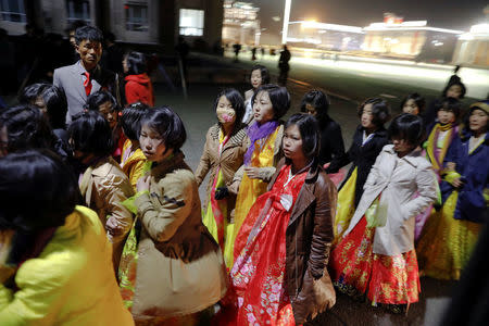 Women dressed in traditional costumes walk near the main Kim Il Sung square in central Pyongyang, North Korea April 11, 2017. REUTERS/Damir Sagolj