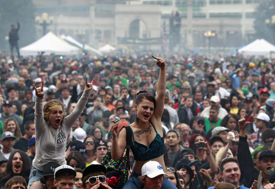 FILE - In this April 20, 2013 file photo, members of a crowd numbering tens of thousands smoke marijuana and listen to live music, at the Denver 420 pro-marijuana rally at Civic Center Park in Denver. Organizers of Denver’s annual April 20 marijuana festival announced on Wednesday, April 2, 2014, that rapper B.o.B and singer Wyclif Jean will headline the event as they try draw a big post-legalization crowd and shake the memory of last year’s event, which was marred by a still-unsolved shooting. (AP Photo/Brennan Linsley, file)