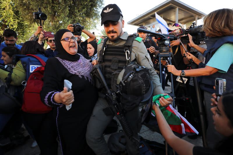 Un policía israelí le quita una bandera israelí a una mujer en medio de una marcha de miles de israelíes en la Puerta de Damasco, en la Ciudad Vieja de Jerusalén