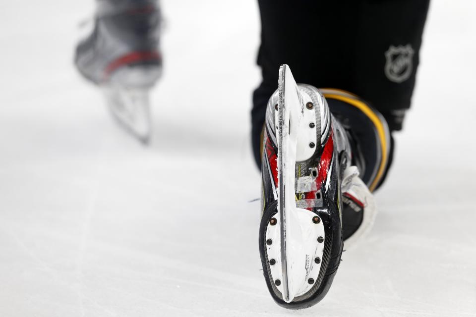 FILE - Boston Bruins' David Pastrnak kneels on the ice during a timeout in the second period of an NHL hockey game against the Dallas Stars in Boston, Thursday, Feb. 27, 2020. The death of American hockey player Adam Johnson from a cut to the neck in England has reignited the debate over skate blade safety. (AP Photo/Michael Dwyer, File)