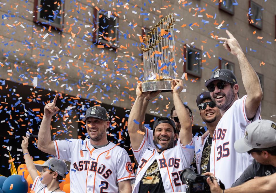 The Houston Astros' Alex Bregman (2), Jose Altuve (27) and Justin Verlander (35) celebrate with the 2022 Commissioner’s Trophy during the championship parade in Houston.
