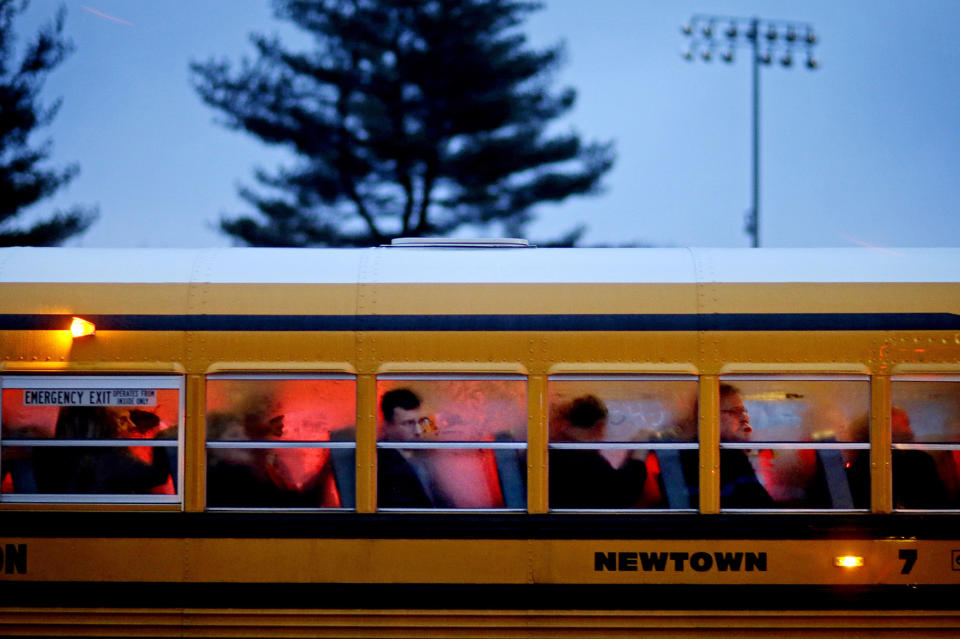 <p>People arrive on a school bus at Newtown High School for a memorial vigil attended by President Barack Obama for the victims of the Sandy Hook Elementary School shooting, Dec. 16, 2012, in Newtown, Conn. (AP Photo/David Goldman) </p>