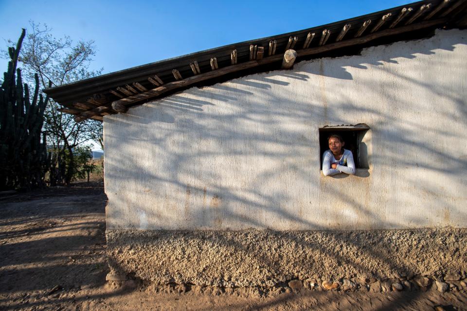 Melissa Sical watches over her cousins from the window of her grandparents' home in early March, about a quarter-mile from her home. It's where her father, Francisco Sical, grew up.