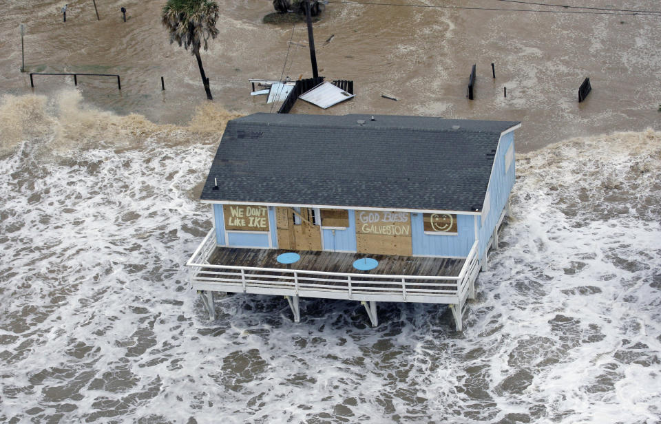 FILE - In this Sept. 12, 2008, file photo, a boarded-up home sits along the beach as Hurricane Ike approaches in Galveston, Texas. The Ike Dike is a proposed coastal barrier that would protect the Houston-Galveston region, including Galveston Bay, from hurricane storm surge. The project was conceived by Bill Merrell, a professor in the Marine Sciences Department at Texas A&M University at Galveston and a former president of the school, in response to the extensive surge damage caused by Hurricane Ike in September of 2008. (AP Photo/David J. Phillip, File)