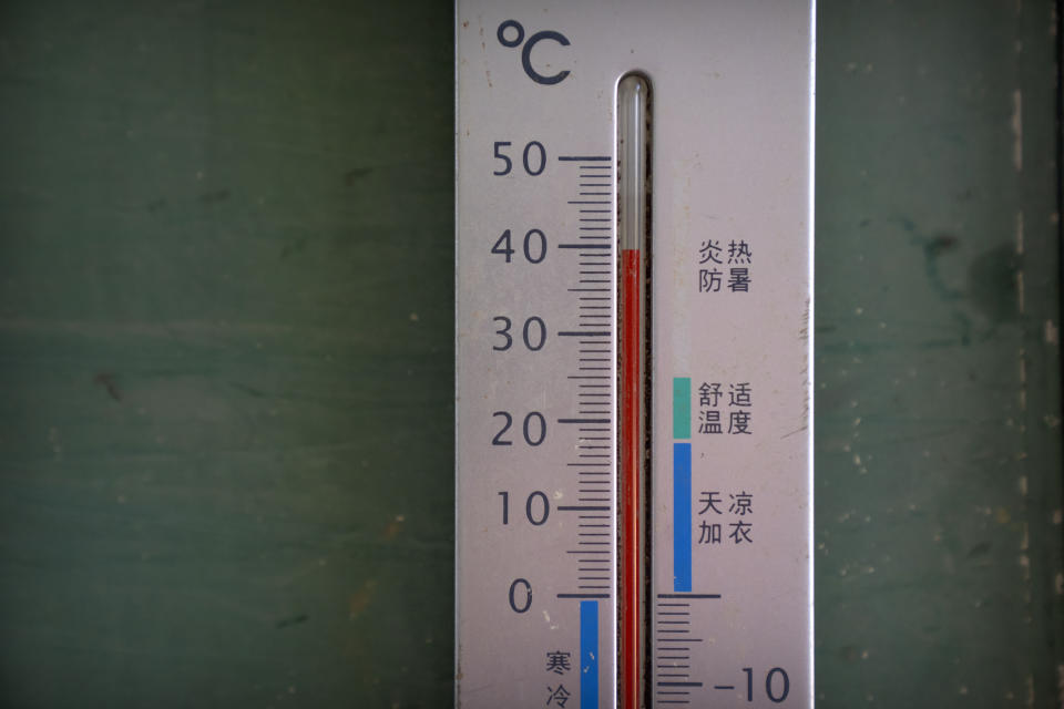 FILE - A thermometer shows a temperature of nearly 40 degrees Celsius (104 F) in the shade before midday in Longquan village in southwestern China's Chongqing Municipality, Saturday, Aug. 20, 2022. The very landscape of Chongqing, a megacity that also takes in surrounding farmland and steep and picturesque mountains, has been transformed by an unusually long and intense heat wave and an accompanying drought. (AP Photo/Mark Schiefelbein, File)