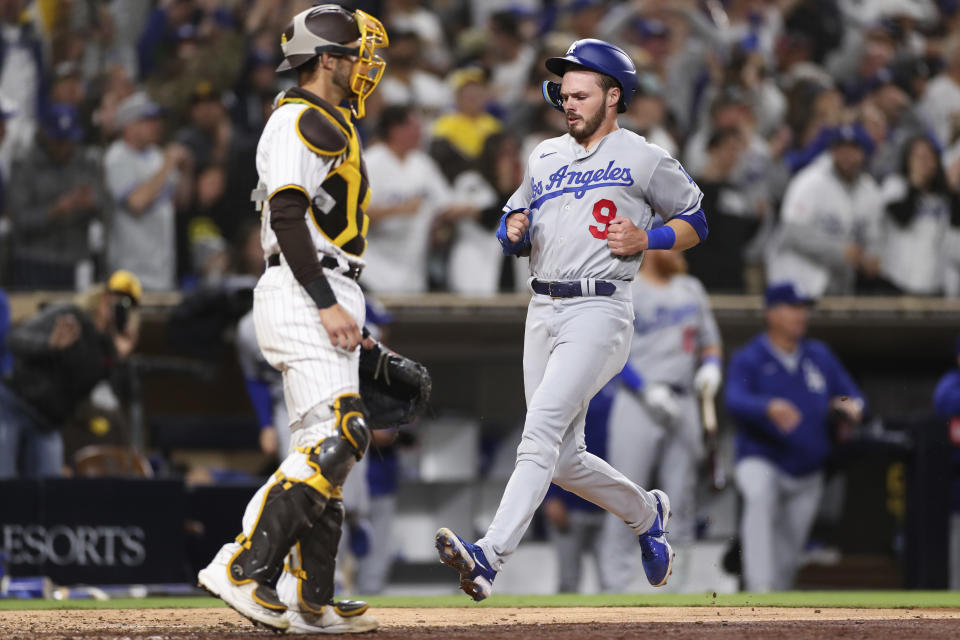 Los Angeles Dodgers' Gavin Lux, right, scores on a two-RBI double by Trea Turner as San Diego Padres catcher Austin Nola, left, looks on in the eighth inning of a baseball game Saturday, April 23, 2022, in San Diego. (AP Photo/Derrick Tuskan)