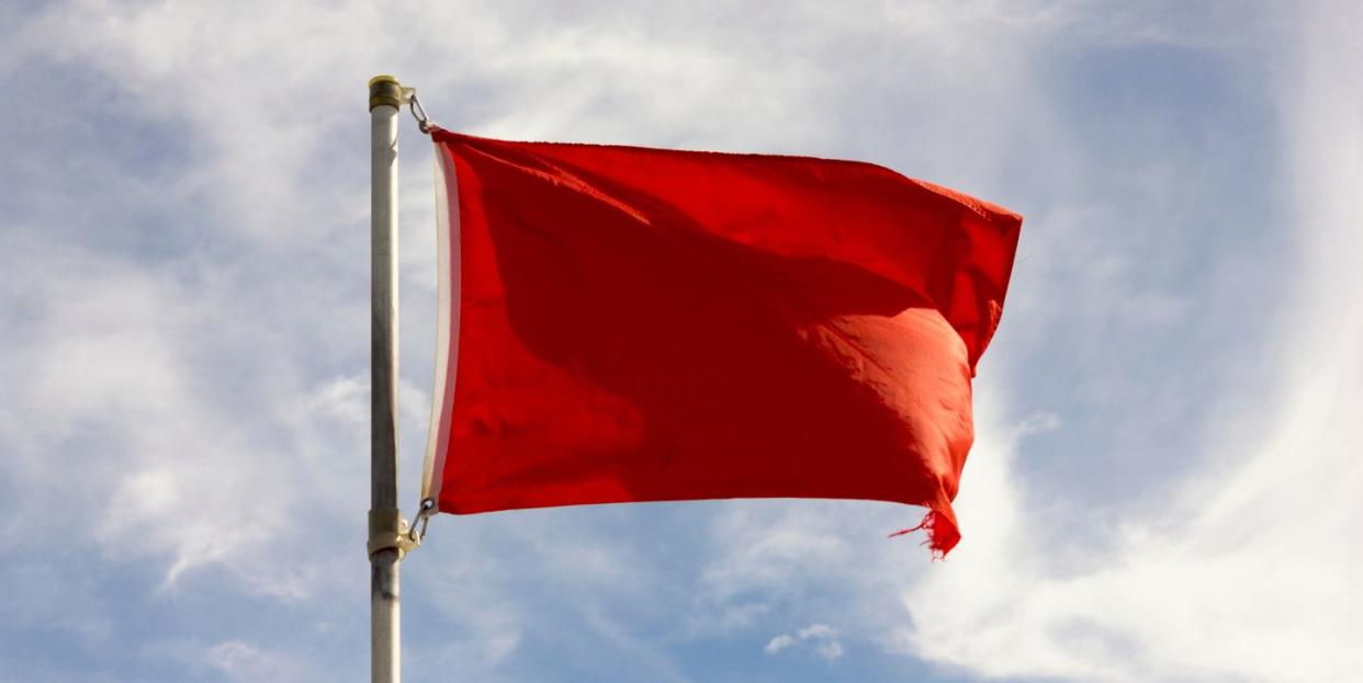 low angle view of red flag against sky