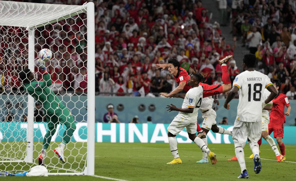 South Korea's Cho Gue-sung heads the ball to score his side's second goal against Ghana's goalkeeper Lawrence Ati-Zigi during the World Cup group H soccer match between South Korea and Ghana, at the Education City Stadium in Al Rayyan, Qatar, Monday, Nov. 28, 2022. (AP Photo/Lee Jin-man)