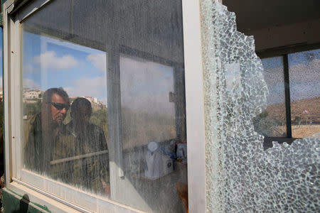 Israeli soldiers look into a security booth damaged during a shooting attack in which a Palestinian gunman killed three Israelis guards and wounded a fourth in a Jewish settlement in the occupied West Bank before he was shot dead, police said, September 26, 2017. REUTERS/Ammar Awad