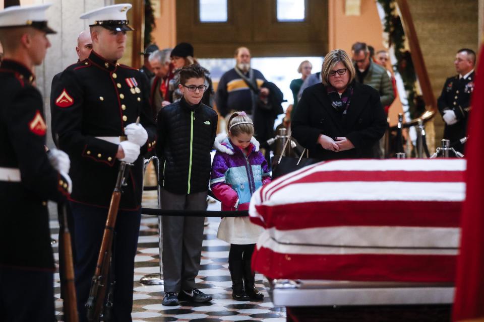 Mourners pause at the casket of John Glenn as he lies in honor, Friday, Dec. 16, 2016, in Columbus, Ohio. Glenn's home state and the nation began saying goodbye to the famed astronaut who died last week at the age of 95. (AP Photo/John Minchillo)