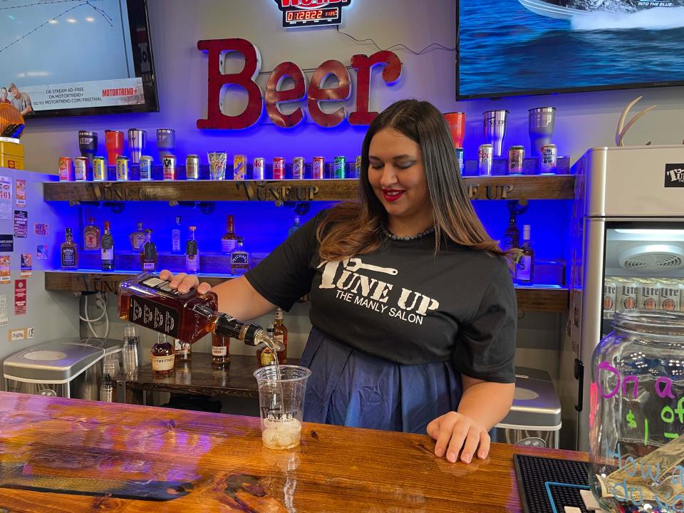 Bartender Jessica Oakes pours a Jack Daniels for a client at Tune Up, The Manly Salon at 6734 Malone Creek Drive Friday, Jan. 28, 2022.