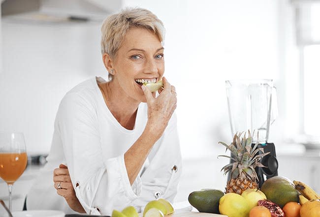 Mujer madura comiendo fruta