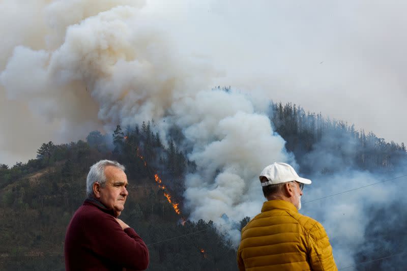 Locals observe a wildfire in Setienes