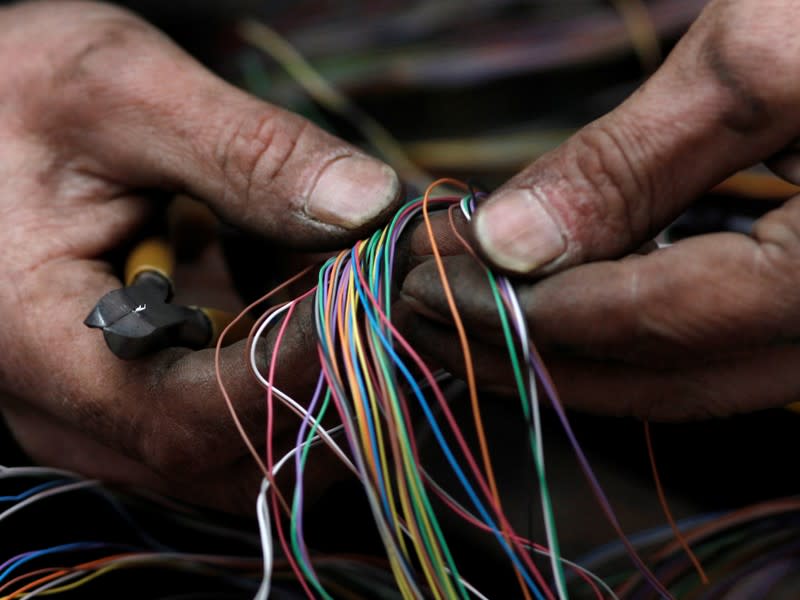 FILE PHOTO: A British Telecom engineer repairs cables to the telephone and internet network in central London