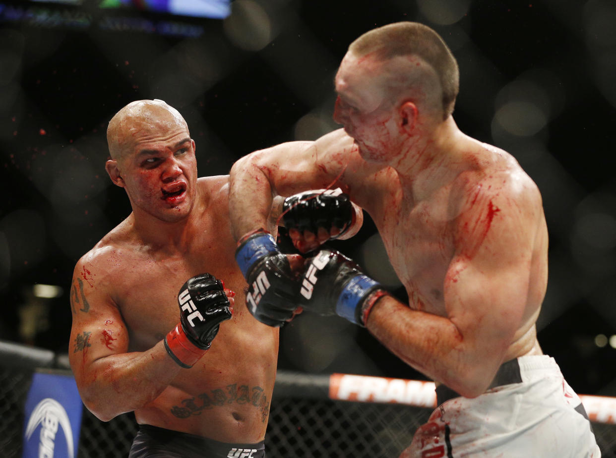 Robbie Lawler , left, lands a left hit to Rory MacDonald to end their welterweight title mixed martial arts bout at UFC 189 on Saturday, July 11, 2015, in Las Vegas. (AP Photo/John Locher)