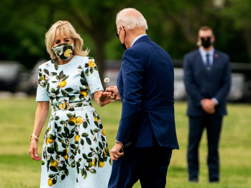 President Joe Biden hands Dr. Jill Biden a dandelion.