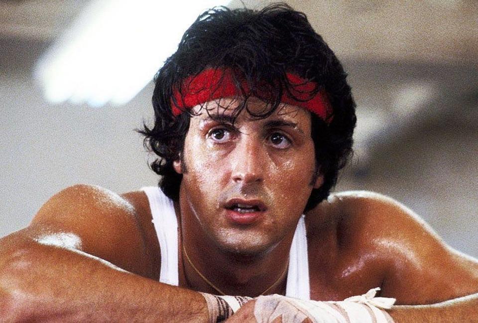 Sylvester Stallone sweaty with a red head band