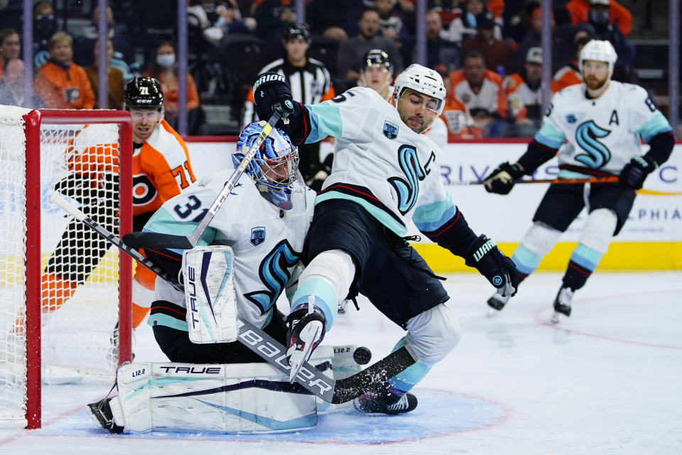 Seattle Kraken's Mark Giordano (5) collides with Philipp Grubauer (31) during the second period of an NHL hockey game against the Philadelphia Flyers, Monday, Oct. 18, 2021, in Philadelphia. (AP Photo/Matt Slocum)