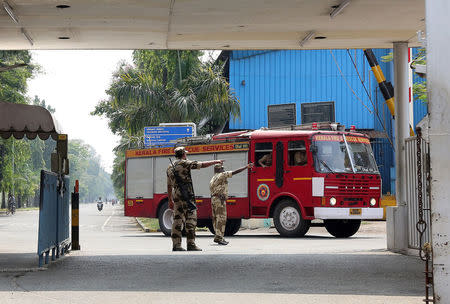 Policemen direct a fire engine after a fire broke out on a ship under repair at the Cochin Shipyard Ltd, in Kochi, India February 13, 2018. REUTERS/Sivaram