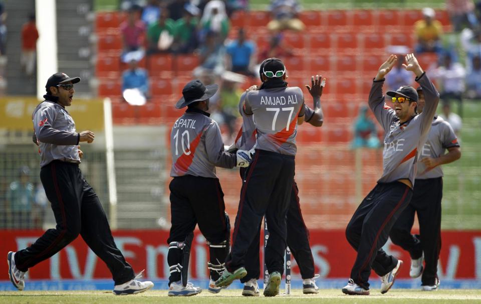 United Arab Emirates' cricket players celebrate the dismissal of Zimbabwe's Hamilton Masakadza during their ICC Twenty20 Cricket World Cup match in Sylhet, Bangladesh, Friday, March 21, 2014. (AP Photo/A.M. Ahad)