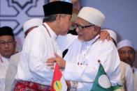 UMNO President Ahmad Zahid Hamidi and PAS President Hadi Awang hug during Ummah Unity Gathering in Kuala Lumpur