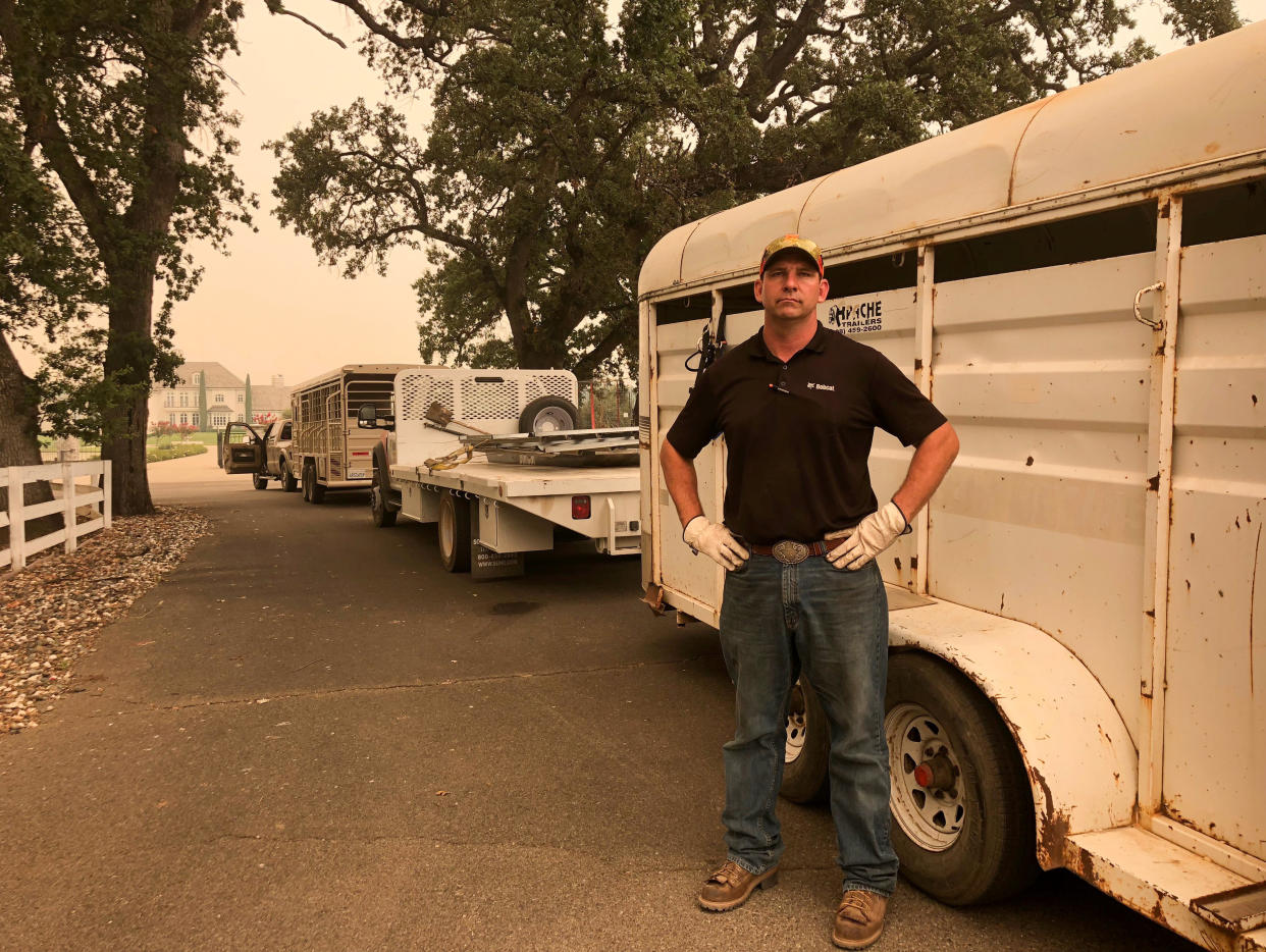 Tucker Zimmerman stands next to the trailer he has used to rescue scores of horses left behind in evacuated areas from a wildfire in Shasta County, west of Redding, California. (Photo: Alexandria Sage/Reuters)