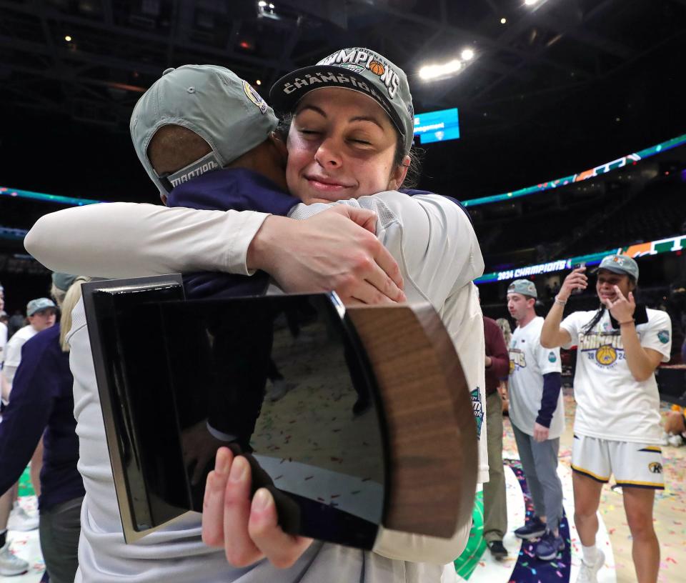Kent State's Katie Shumate (14) hugs a member of the coaching staff after the Golden Flashes defeated Buffalo to win the Mid-American Conference Tournament women's basketball championship Saturday in Cleveland.