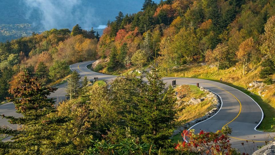 Oct. 9, 2023: The park road at Grandfather Mountain provides a nice snapshot of the current landscape. While some vibrant trees and pockets of color dot the hillsides, there is still much to come. Overall in the region, a lot of green remains. This view from the switchbacks near the top of the mountain shows the entrance of the Bridge Trail across from the Black Rock parking lot.