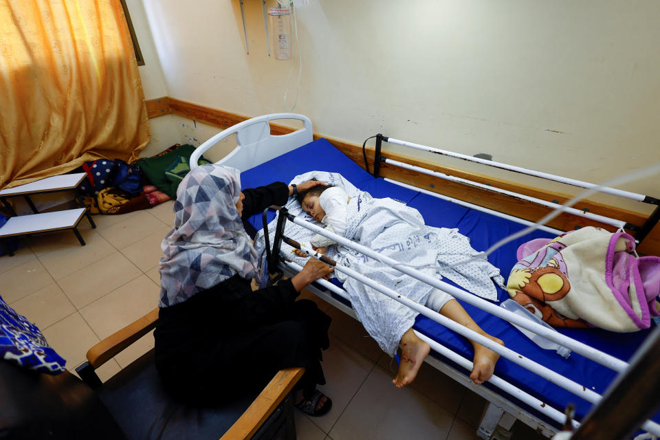 Palestinian girl Fulla Al-Laham, 4, who was wounded in an Israeli strike that killed 14 family members, including her parents and all her siblings, lies on a bed as her grandmother sits next to her, at a hospital in Khan Younis in the southern Gaza Strip, October 14, 2023. REUTERS/Mohammed Salem