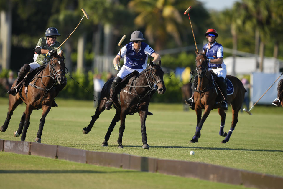 Britain's Prince Harry, center, races for a ball as he plays in the 2024 Royal Salute Polo Challenge to Benefit Sentebale, Friday, April 12, 2024, in Wellington, Fla. Prince Harry, co-founding patron of the Sentebale charity, will play on the Royal Salute Sentebale Team. (AP Photo/Rebecca Blackwell)