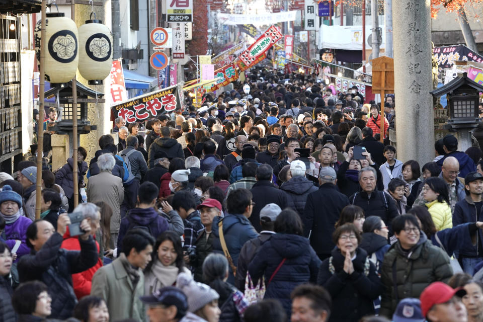 In this Tuesday, Dec. 3, 2019, photo, people walk on the road to the Chichibu Shrine during the Chichibu Night Festival in Chichibu, Japan. The festival draws about 200,000 every December.(AP Photo/Toru Hanai)