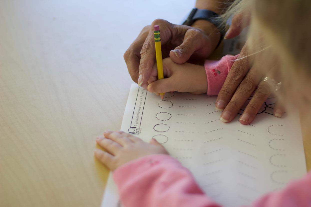 Kindergarten teacher Tracy Reed helps her student practice tracing shapes Sept. 12 at César E. Chávez Elementary School.