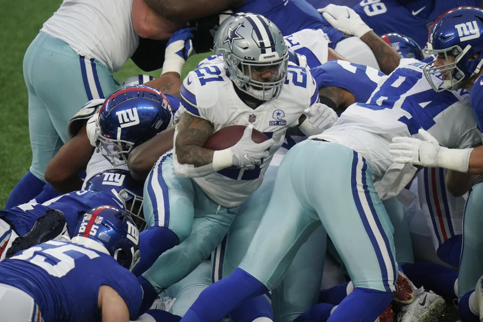 Dallas Cowboys' Ezekiel Elliott, center, pushes through New York Giants defenders to score a touchdown during the second half of an NFL football game, Sunday, Jan. 3, 2021, in East Rutherford, N.J. (AP Photo/Frank Franklin II)