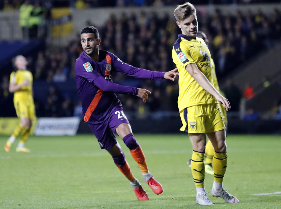 Manchester City's Riyad Mahrez, left, celebrates after scoring his side's second goal during the English League Cup soccer match between Oxford United and Manchester City at the Kassam Stadium in Oxford, England, Tuesday, Sept. 25, 2018. (AP Photo/Frank Augstein)