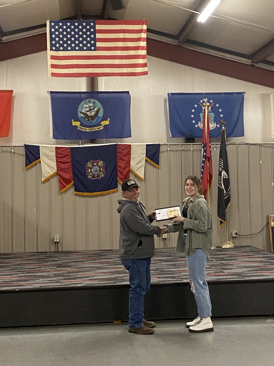 Robert Hurst gives Jaden Perry an award for being the senior high first-place winner at Wednesday's ceremony.