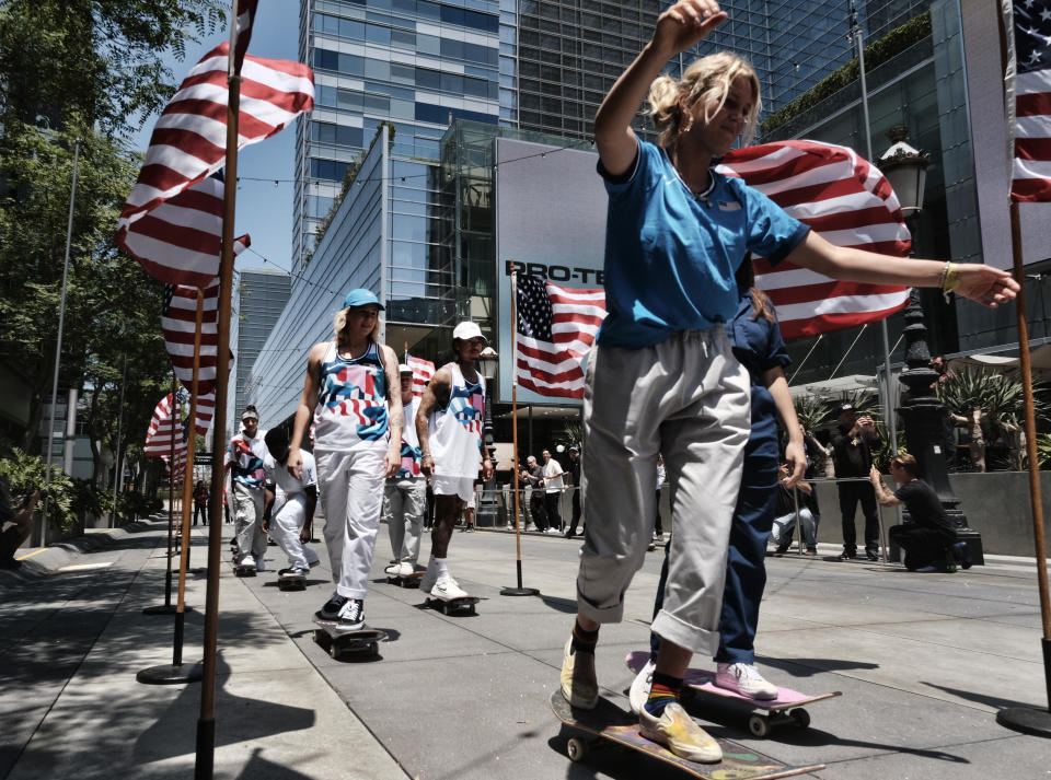 Members of the first U.S. Olympic skateboarding team arrive on their boards for a news conference in downtown Los Angeles on Monday, June 21, 2021. The team was introduced in Southern California, where the sport was invented roughly 70 years ago. Skateboarding is an Olympic sport for the first time in Tokyo, and the Americans are expected to be a strong team. (AP Photo/Richard Vogel)