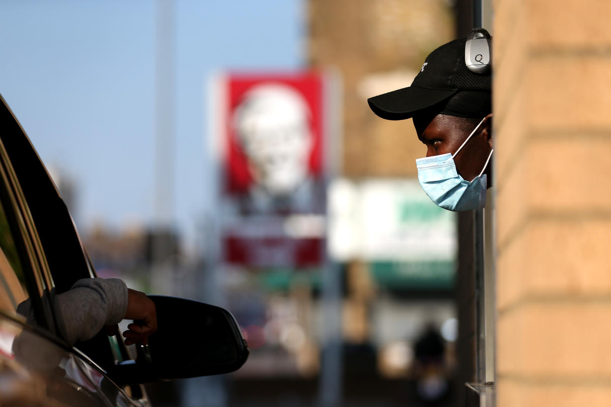 LONDON, UNITED KINGDOM - MAY 04: A worker speaks to a customer at KFC as it re-opens for Drive-Thru at a branch in Leyton on May 04, 2020 in London, United Kingdom. The country continued quarantine measures intended to curb the spread of Covid-19, but the infection rate is falling, and government officials are discussing the terms under which it would ease the lockdown. (Photo by Alex Pantling/Getty Images)