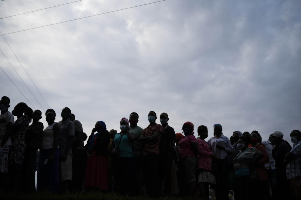 Ugandans wait to vote in Kampala, Uganda, Thursday, Jan. 14, 2021. Ugandans are voting in a presidential election tainted by widespread violence that some fear could escalate as security forces try to stop supporters of leading opposition challenger BobiWine from monitoring polling stations.(AP Photo/Jerome Delay)