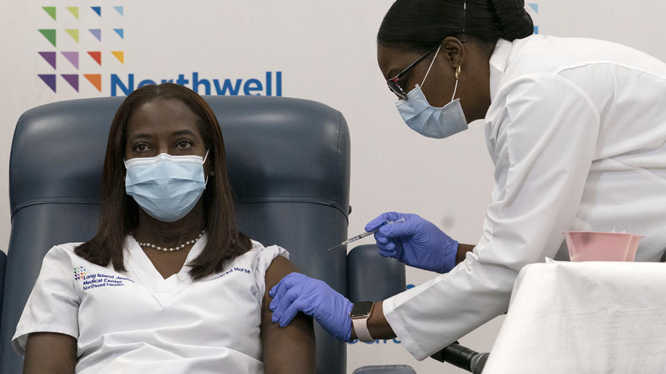 Sandra Lindsay, left, a nurse at New York's Long Island Jewish Medical Center, was inoculated with the Pfizer-BioNTech COVID-19 vaccine by Dr. Michelle Chester on Monday.