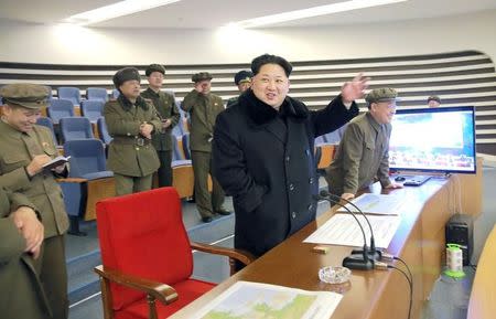 North Korean leader Kim Jong Un (C) reacts as he watches a long range rocket launch in North Korea, in this photo released by Kyodo February 7, 2016. REUTERS/Kyodo