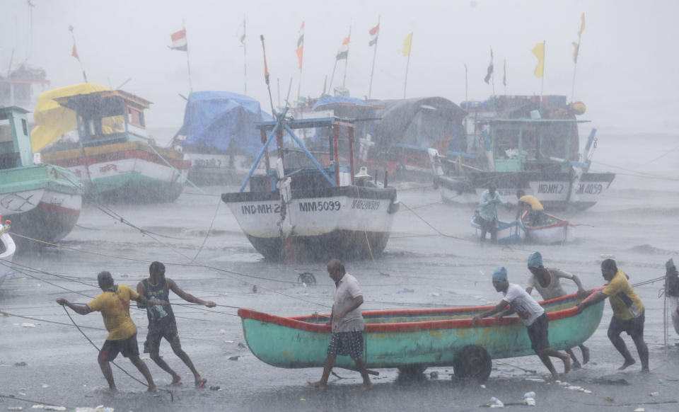 Fishermen try to move a fishing boat to a safer ground on the Arabian Sea coast in Mumbai, India, Monday, May 17, 2021. Cyclone Tauktae, roaring in the Arabian Sea was moving toward India's western coast on Monday as authorities tried to evacuate hundreds of thousands of people and suspended COVID-19 vaccinations in one state. (AP Photo/Rafiq Maqbool)