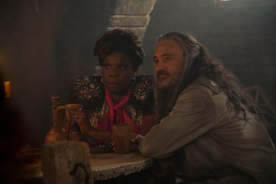 Leslie Jones and Taika Waititi sitting at a table in a still from 'Our Flag Means Death’