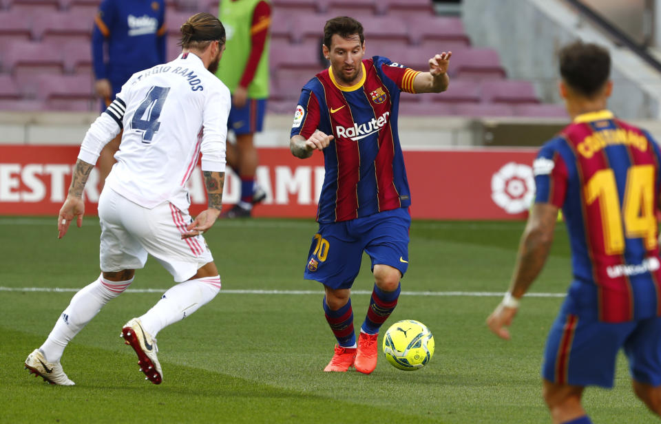 El delantero argentino Lionel Messi disputa el balón con Sergio Ramos del Real Madrid en el partido por La Liga de España, el sábado 24 de octubre de 2020. (AP Foto/Joan Monfort)