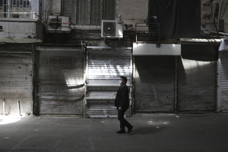 A man walks through closed Tehran's Grand Bazaar, Iran, Saturday, April 10, 2021. Iran on Saturday imposed partial lockdown on businesses in major shopping centers as well as intercity travels through personal cars in major cities including capital Tehran as it struggles with the worst outbreak of the coronavirus in the Mideast region. (AP Photo/Vahid Salemi)