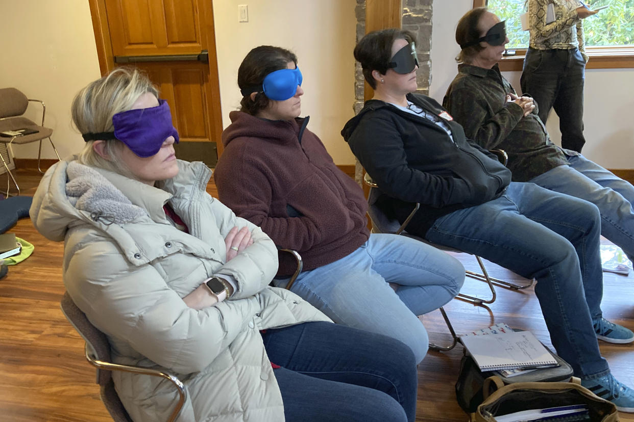 Psilocybin facilitator students sit with eye masks on while listening to music during an experiential activity at a training session near Damascus, Ore., on Dec. 2, 2022. They are being trained in how to accompany patients tripping on psilocybin as Oregon prepares to become the first state in America to offer controlled use of the psychedelic mushroom to the public. (AP Photo/Andrew Selsky)