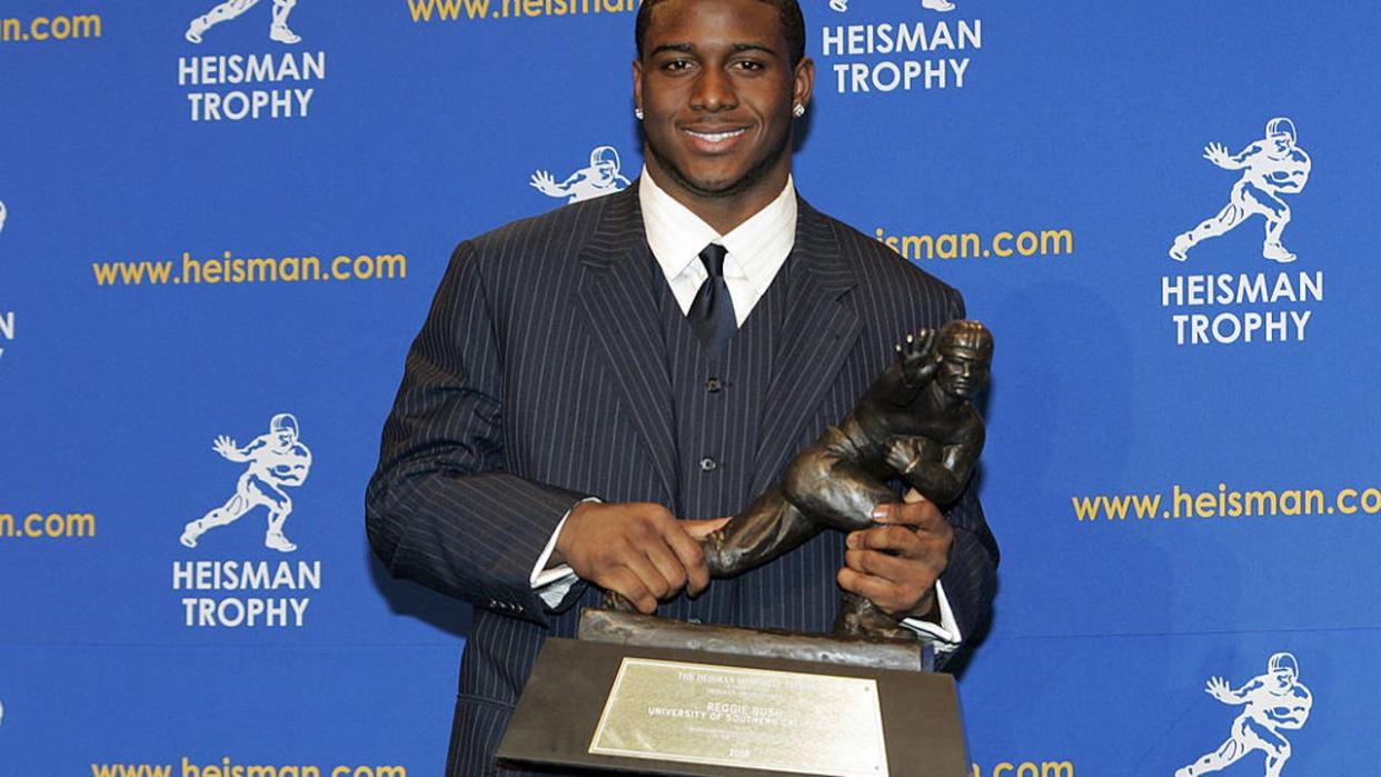 <div>Reggie Bush, University of Southern California tailback holds the Heisman Trophy during the 2005 Heisman Trophy presentation at the Hard Rock Cafe in New York City, New York on December 10, 2005. Bush received 2,541 points in the ballot. (Photo by Michael Cohen/WireImage)</div> <strong>(Getty Images)</strong>
