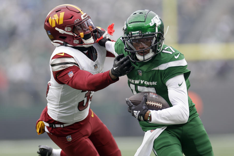 New York Jets wide receiver Garrett Wilson (17) stiff arms Washington Commanders safety Percy Butler (35) during the first quarter of an NFL football game, Sunday, Dec. 24, 2023, in East Rutherford, N.J. (AP Photo/Adam Hunger)