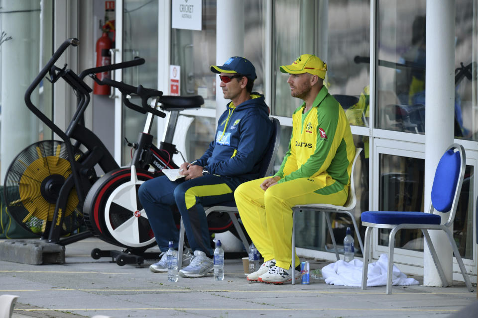 Australia's captain Aaron Finch, right, watches the game with team coach Justin Langer after being dismissed during the second Twenty20 cricket match between England and Australia, at the Ageas Bowl in Southampton, England, Sunday, Sept. 6, 2020. (Dan Mullan/Pool via AP)